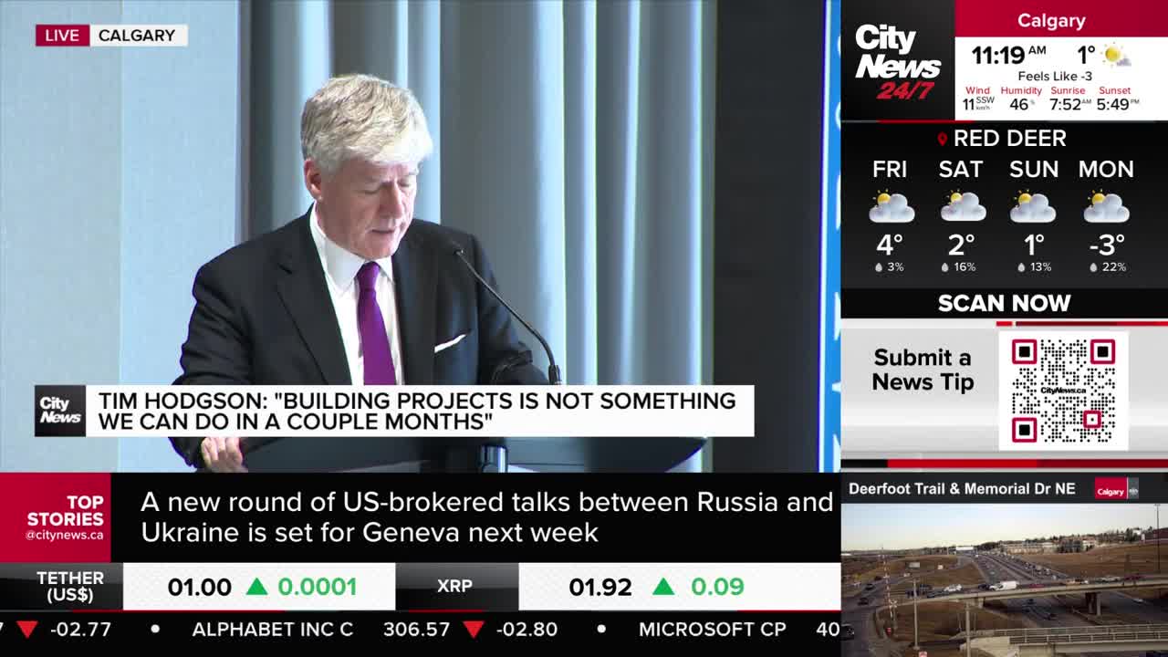 A man in a suit and purple tie speaks at a podium, his words displayed on screen. A CityNews Calgary broadcast shows a weather forecast for Red Deer and a live traffic camera view of Deerfoot Trail.