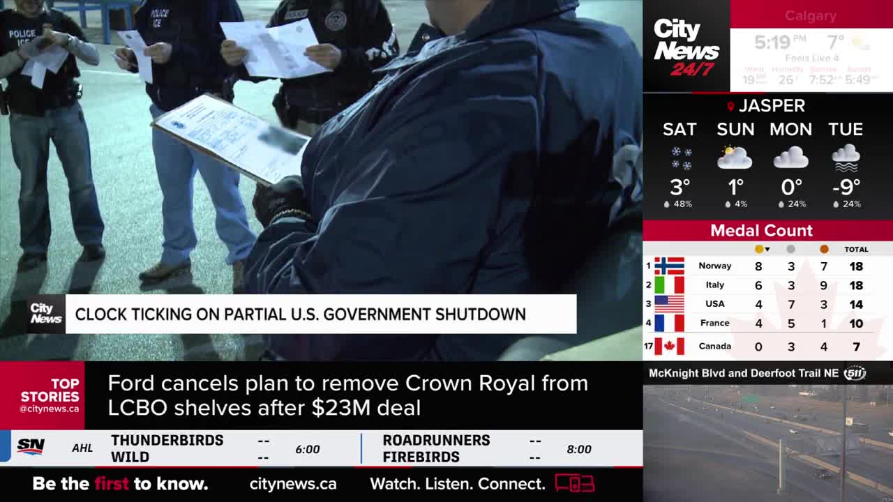 Several officers in dark jackets stand together, reviewing papers under dim lighting. A CityNews Calgary graphic displays the current temperature in Jasper, showing a cold -9 degrees Celsius.