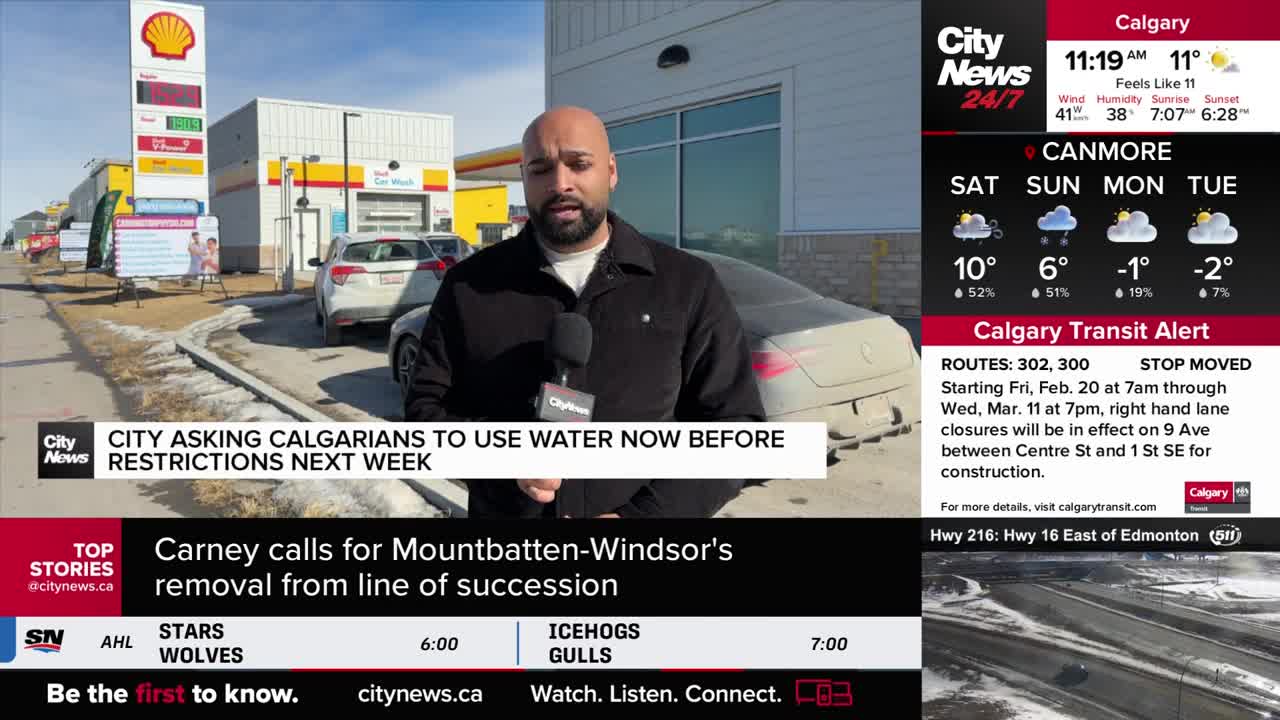 A reporter stands outside a Shell gas station in Calgary, holding a microphone. Behind him, cars are parked near a car wash, and a sign announces water restrictions.