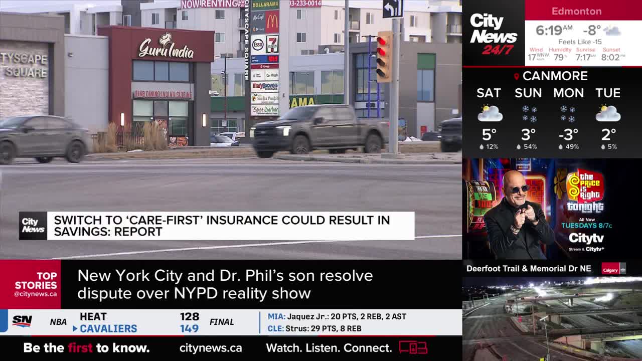 A dark grey pickup truck turns right at the intersection, its headlights cutting through the overcast sky. Across the street, a dark sedan speeds past a row of storefronts, including "Guru India."