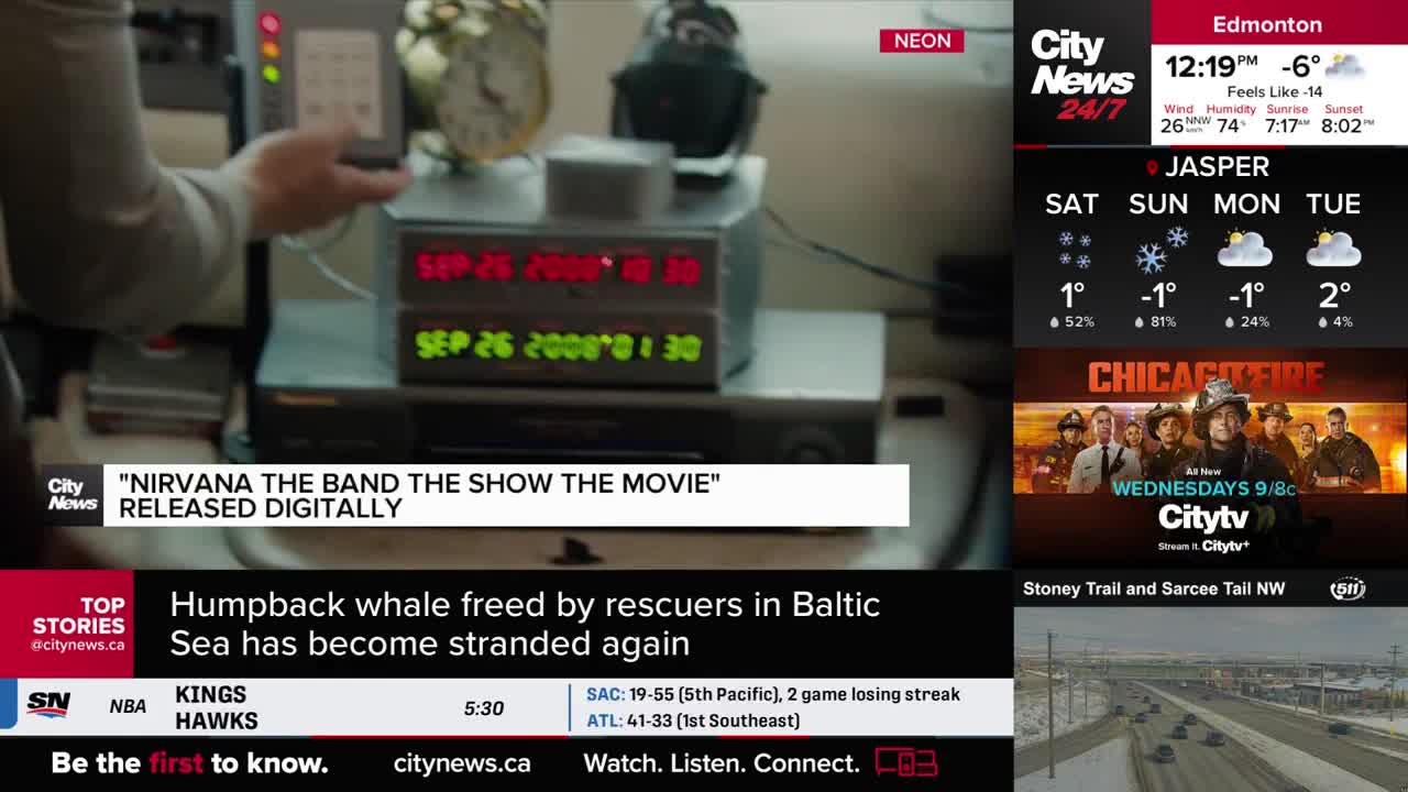 A hand adjusts a device with red and green digital displays showing dates and times. A CityNews Calgary chyron announces "Nirvana The Band The Show The Movie" is released digitally.