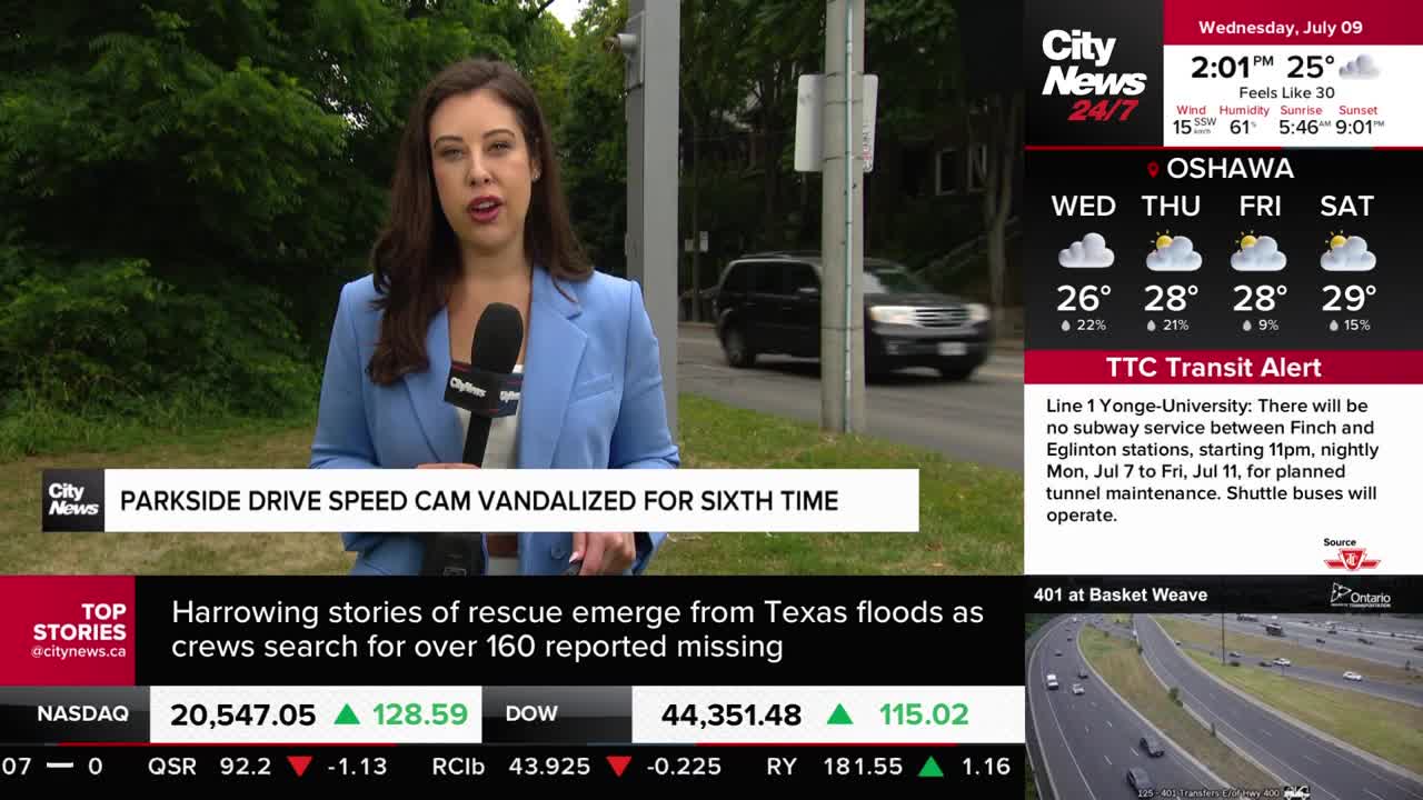 A CityNews Toronto reporter stands on the side of a road, speaking into a microphone. A black SUV drives past behind her, and the chyron reports on a vandalized speed camera.
