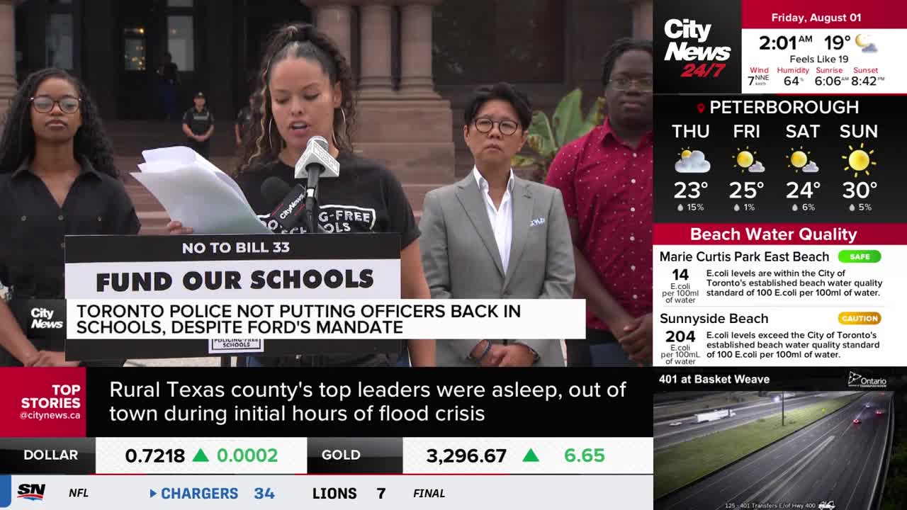 A woman speaks into a microphone, reading from a stack of papers, with "Fund Our Schools" displayed on a sign behind her. CityNews Toronto's broadcast shows a weather report and financial updates in the corner.
