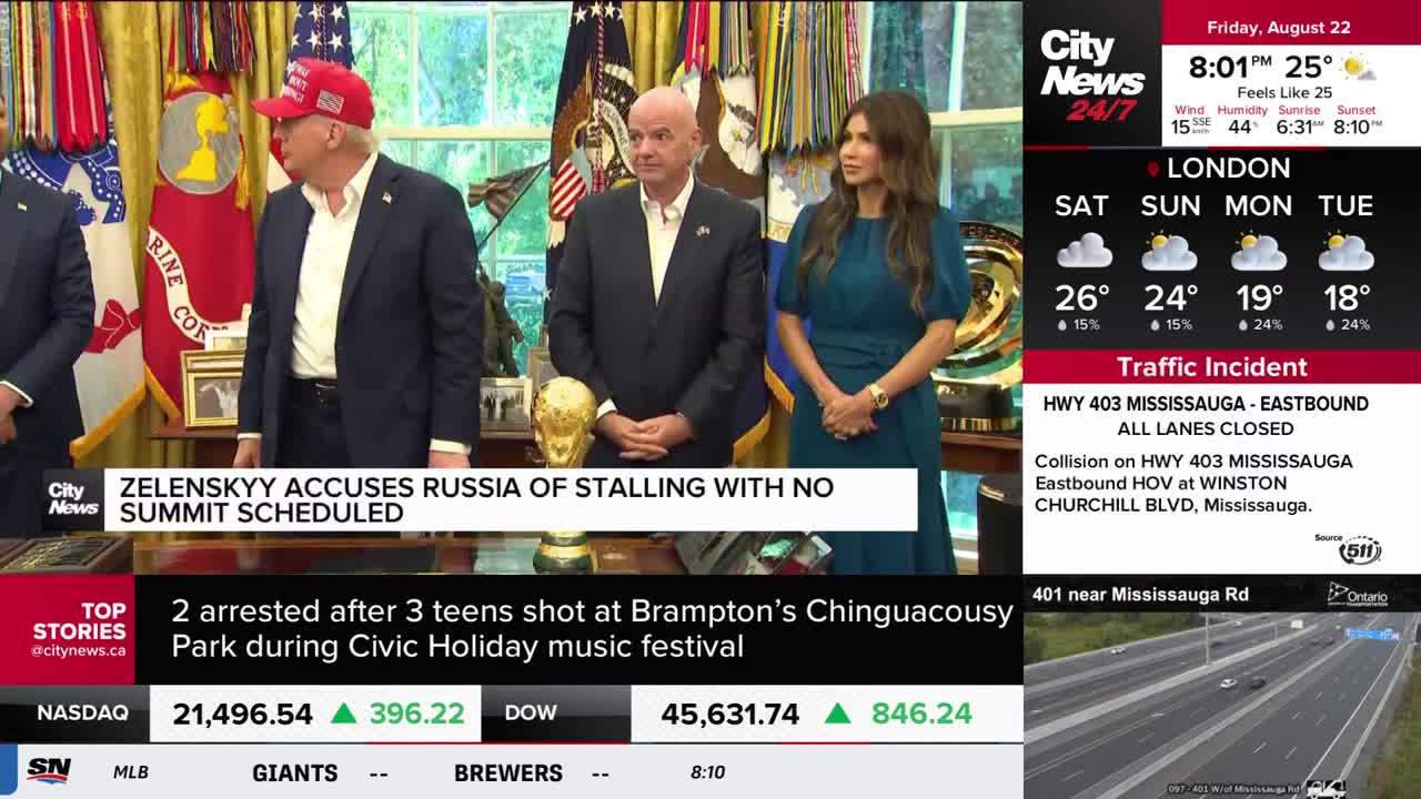 A news broadcast from CityNews Toronto shows a group of people standing in a room, with a chyron about Zelenskyy and Russia at the bottom. Beside the main screen, the weather forecast for London and a traffic incident in Mississauga are displayed.
