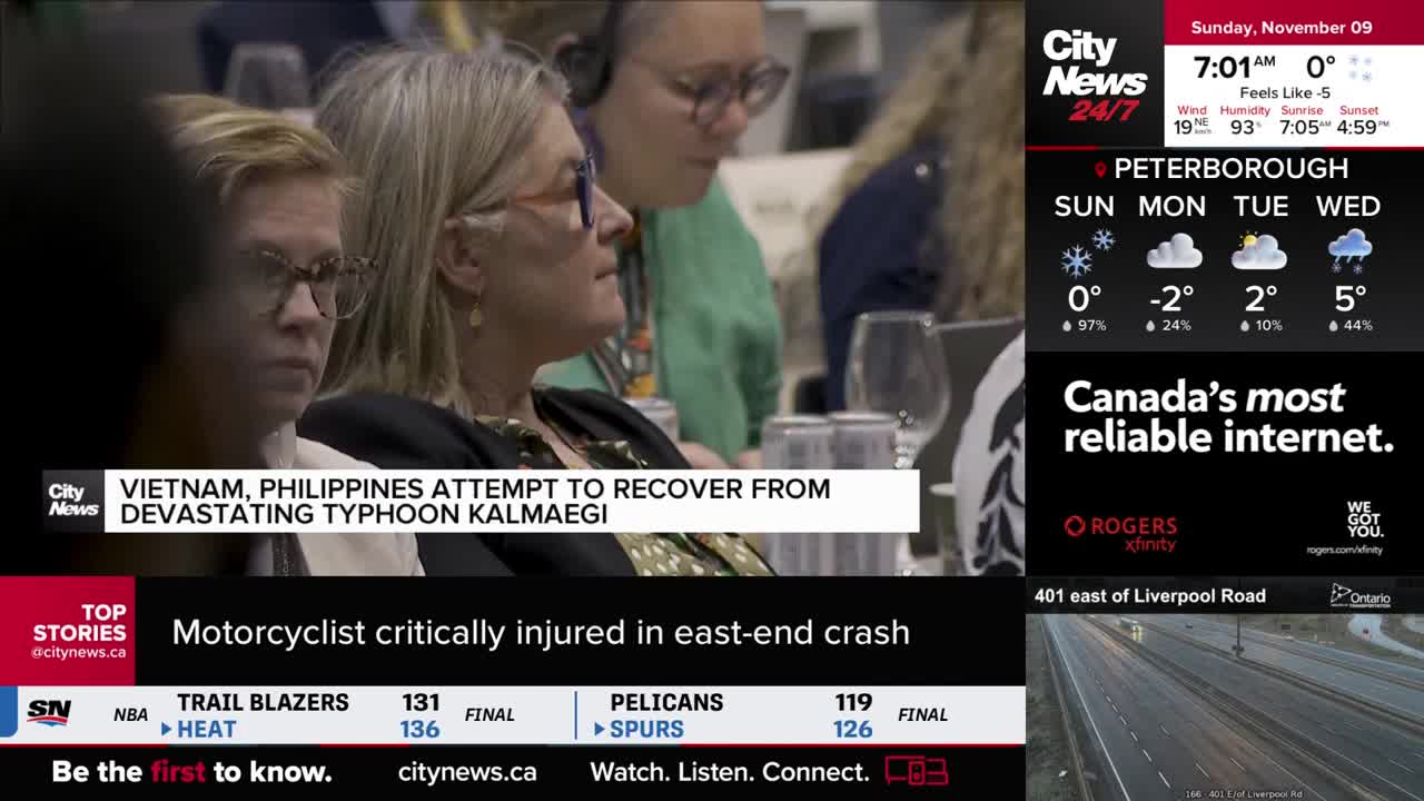 Three women are seated, watching something off-camera, their faces focused. A CityNews Toronto graphic displays the weather forecast for Peterborough and a headline about a motorcycle accident.
