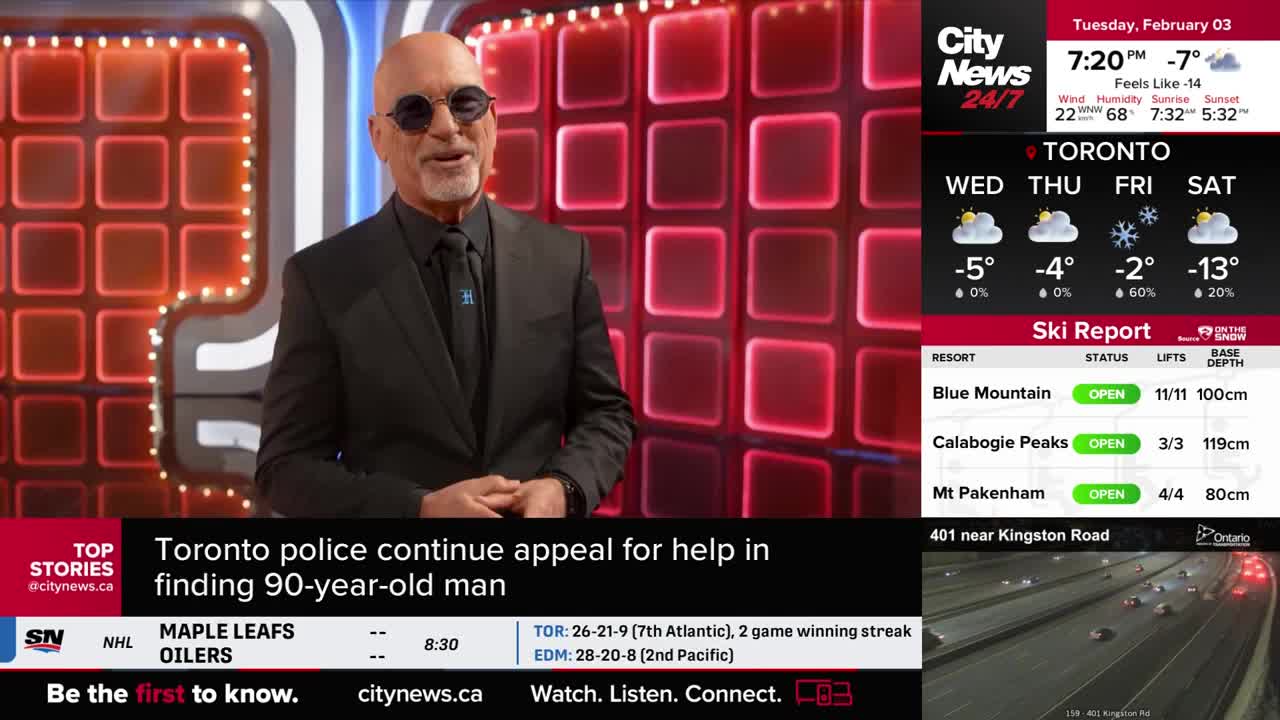 A man in a black suit and sunglasses stands before a wall of glowing red squares. CityNews Toronto displays the day's weather and ski reports, along with a traffic camera view of Highway 401.