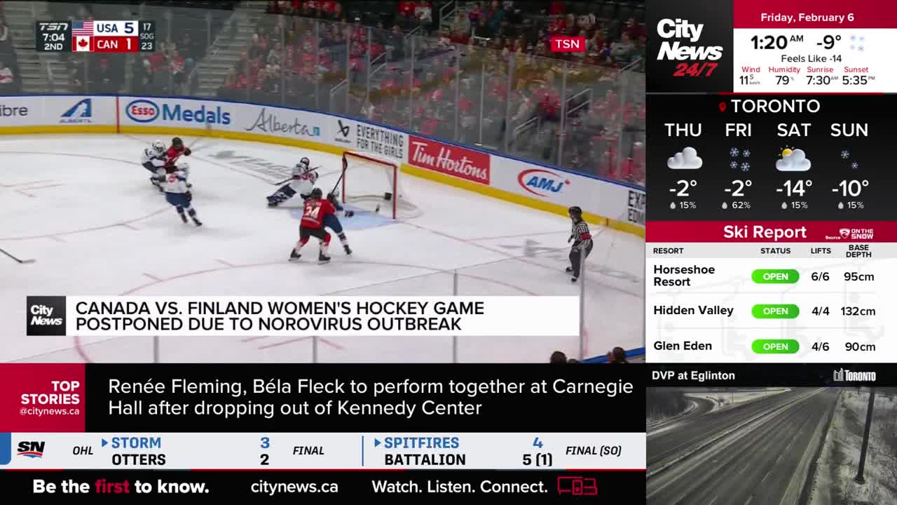Players in red and white jerseys are battling for the puck near the net. A banner across the ice announces the postponement of a Canada vs. Finland women's hockey game due to a norovirus outbreak.