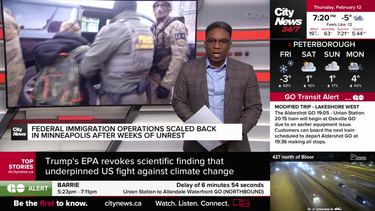 Federal agents escort a person in handcuffs away from a vehicle. On the screen behind them, the headline reads "FEDERAL IMMIGRATION OPERATIONS SCALED BACK IN MINNEAPOLIS AFTER WEEKS OF UNREST."