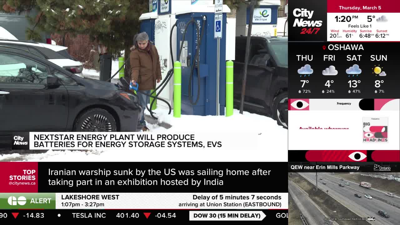 A person in a brown jacket is plugging an electric car into a charging station in the snow. CityNews Toronto is reporting on a new energy plant.