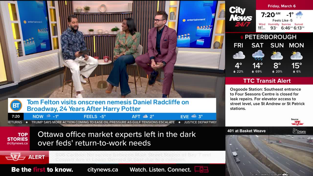 A man in a patterned shirt and white pants holds a tablet while speaking to a woman in a green and brown patterned jacket. Beside them, a man in a maroon suit and glasses leans forward. A CityNews Toronto graphic displays weather for Peterborough and a TTC transit alert.