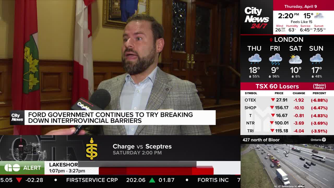 A man with a beard speaks into a microphone, his words about the Ford government's efforts to break down interprovincial barriers are displayed on a CityNews Toronto graphic. Behind him, the Ontario and Canadian flags hang.