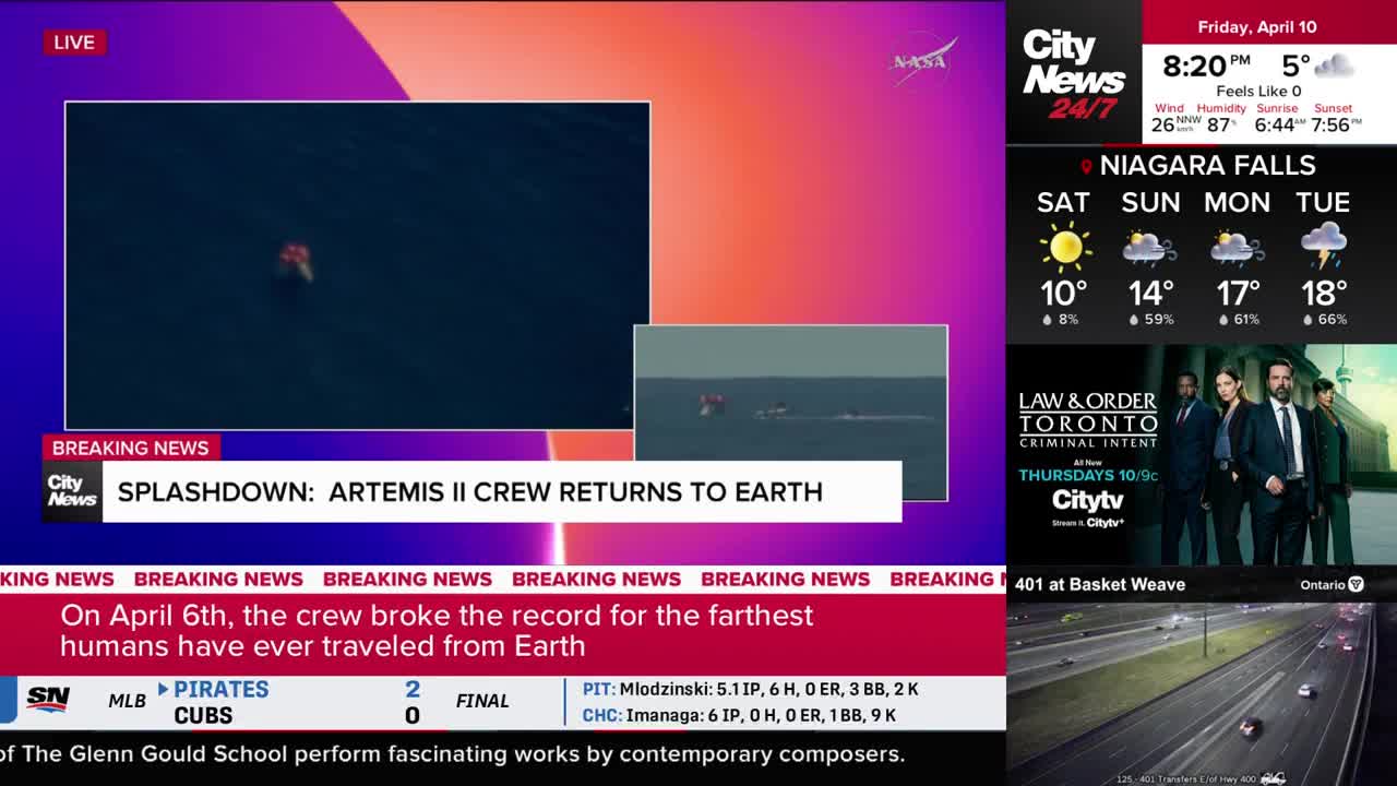 A capsule, bright orange against the dark ocean, bobs on the water. Rescue boats are approaching the splashdown site. A capsule, bright orange against the dark ocean, bobs on the water. Rescue boats are approaching the splashdown site.