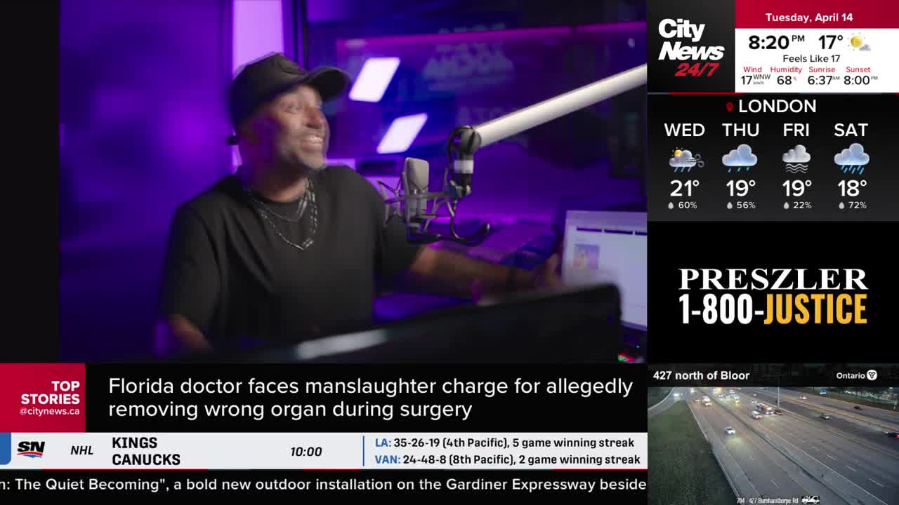 A man in a black t-shirt and baseball cap is speaking into a microphone under purple lights. On a screen beside him, a news ticker reports a Florida doctor faces manslaughter charges for allegedly removing the wrong organ during surgery.