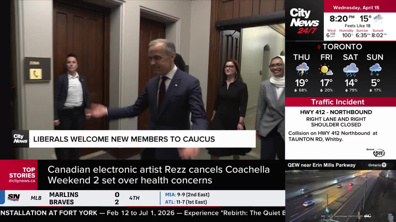 A man in a suit and tie walks through a doorway, followed by two women. One woman wears a black dress, and the other a grey blazer over a hijab.