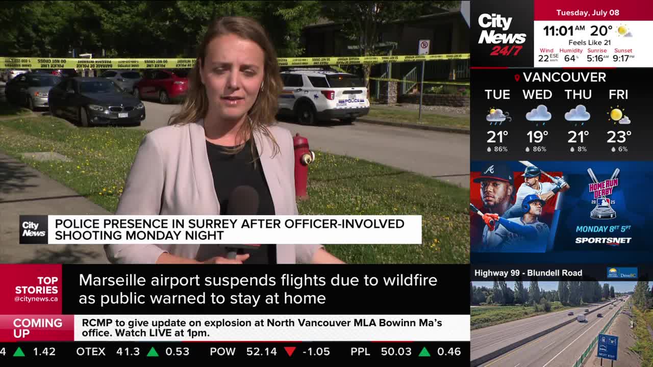 A CityNews Vancouver reporter stands in front of a police scene, speaking into a microphone. Yellow tape blocks off the area, and a police cruiser is parked on the street behind her.
