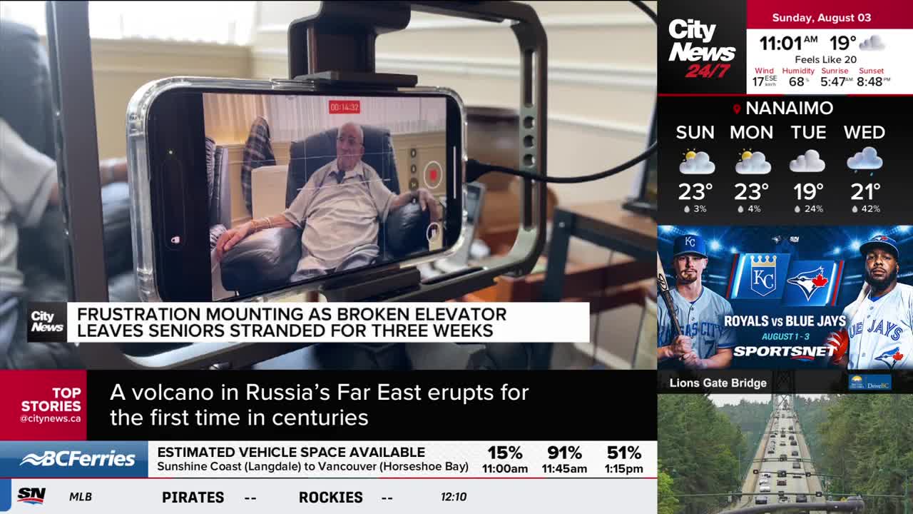 A smartphone, mounted on a rig, displays a CityNews Vancouver report about seniors stranded by a broken elevator. The feed shows an elderly man sitting in a chair, likely being interviewed.
