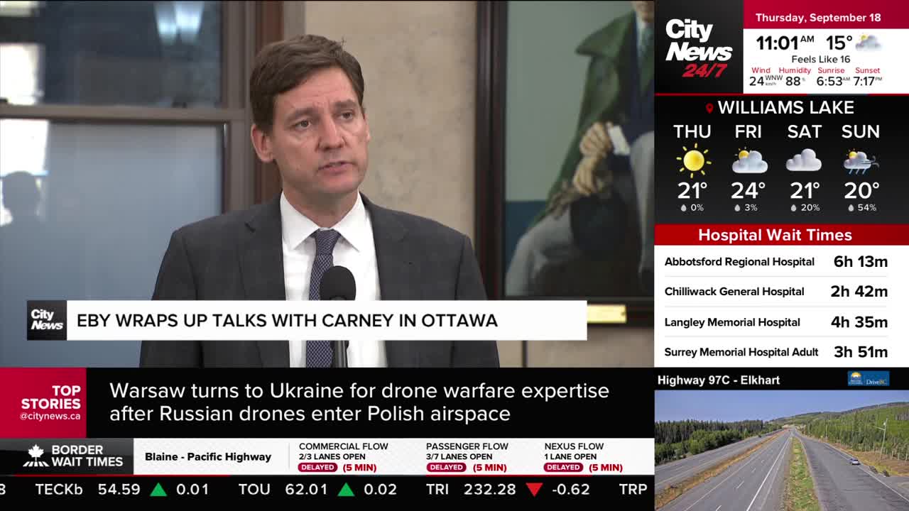 A man in a suit speaks into a microphone, his words likely broadcast by CityNews Vancouver. The screen displays headlines and local information, including weather and hospital wait times.

