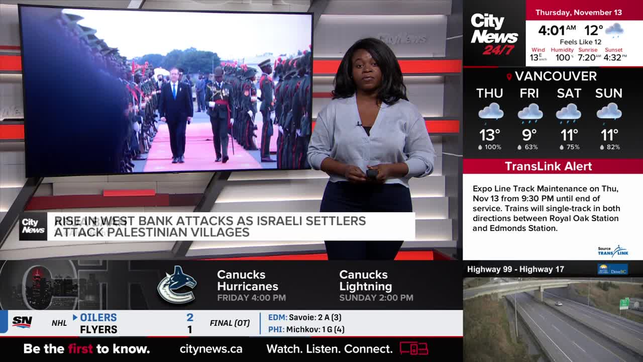 A news anchor in a light-colored sweater stands in front of a screen. The screen shows a man in a suit walking with military figures, and the headline reads "Rise in West Bank Attacks."
A news anchor in a light-colored sweater stands in front of a screen. The screen shows a man in a suit walking with military figures, and the headline reads "Rise in West Bank Attacks."