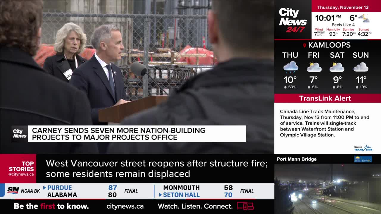 A man in a suit speaks into a microphone, with a CityNews banner beneath him. Behind him, a woman stands quietly, and the background shows construction.
A man in a suit speaks into a microphone, with a CityNews banner beneath him. Behind him, a woman stands quietly, and the background shows construction.