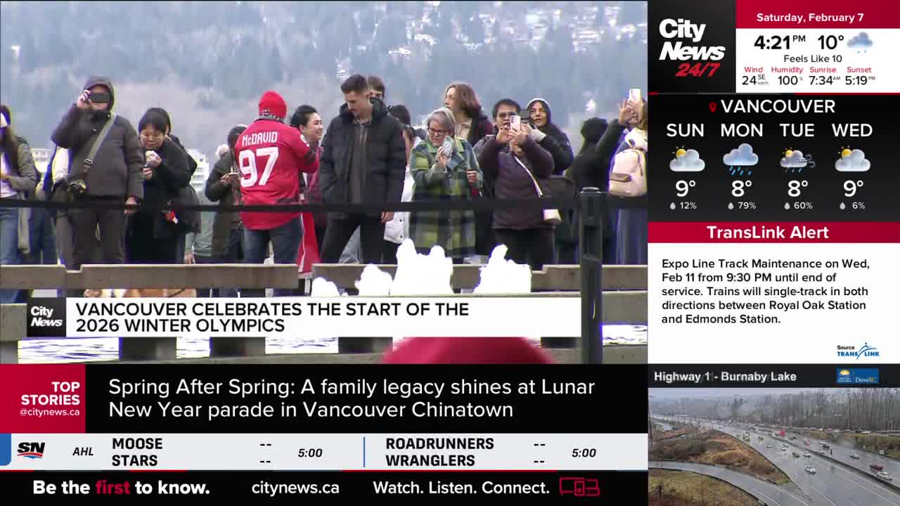 A crowd gathers, many holding up phones to capture the moment. A person in a red jersey with the number 97 stands out amongst them.