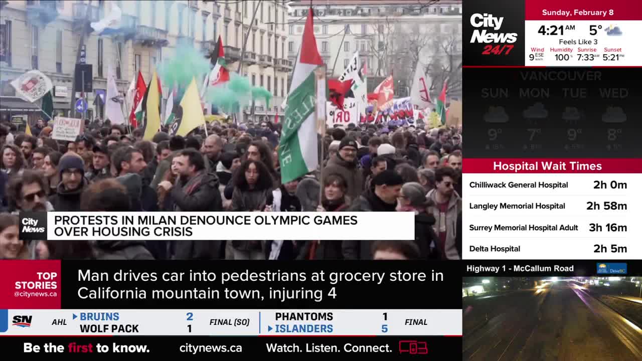 A dense crowd surges forward, many holding flags and some releasing plumes of green smoke. The CityNews Vancouver screen displays a report about protests in Milan.
