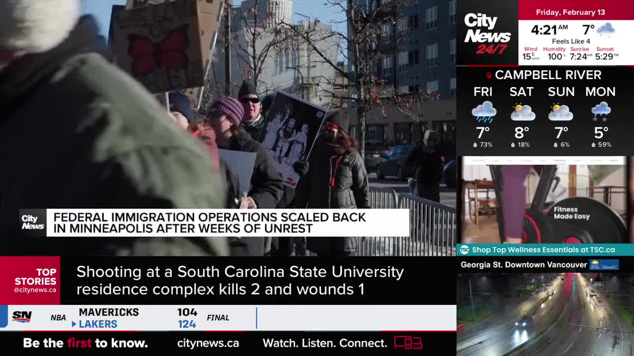 People are holding signs and a framed picture, standing behind a metal barrier. A CityNews Vancouver broadcast displays headlines about federal immigration operations and a shooting. People are holding signs and a framed picture, standing behind a metal barrier. A CityNews Vancouver broadcast displays headlines about federal immigration operations and a shooting.