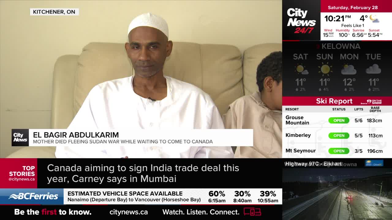 A man in a white cap and robe sits on a couch, his gaze directed forward. Beside him, a younger person in similar attire looks down. A man in a white cap and robe sits on a couch, his gaze directed forward. Beside him, a younger person in similar attire looks down.