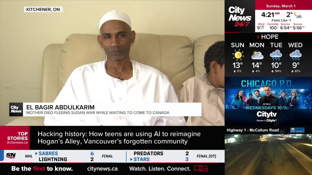 A man in a white shirt and cap sits on a couch, his gaze directed forward. Beside him, a younger person is partially visible, facing away from the camera. A man in a white shirt and cap sits on a couch, his gaze directed forward. Beside him, a younger person is partially visible, facing away from the camera.