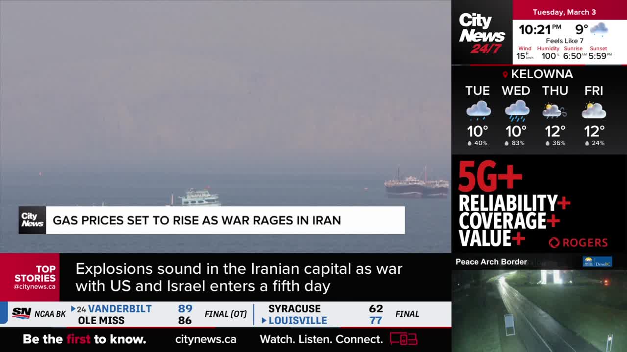 A white ferry glides across the hazy water, dwarfed by a larger cargo ship anchored further out. CityNews Vancouver's broadcast plays on a screen, with headlines scrolling below.