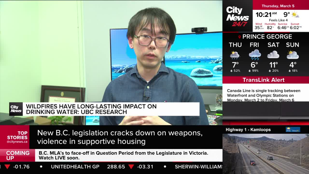 A man in a blue collared shirt speaks directly to the camera, his hands clasped in front of him. A graphic behind him reads "Wildfires have long-lasting impact on drinking water: UBC research."