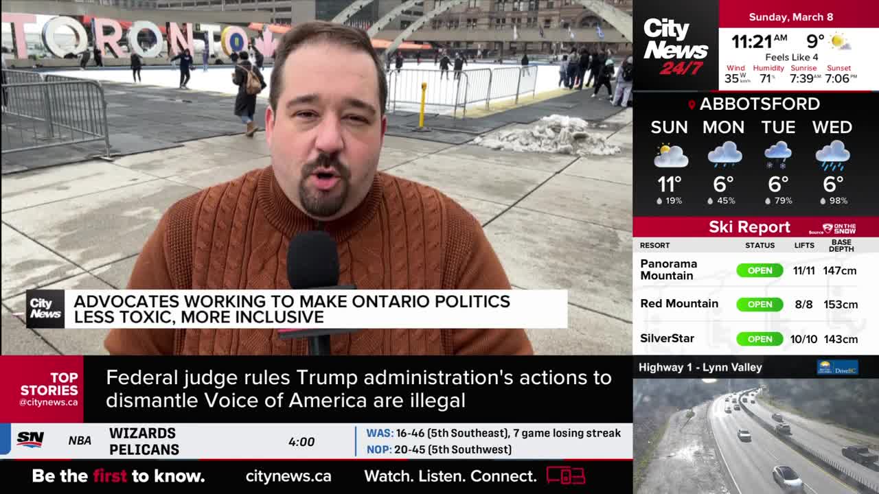 A reporter stands in front of a large "TORONTO" sign, speaking into a microphone. Behind him, people skate on an outdoor rink.
