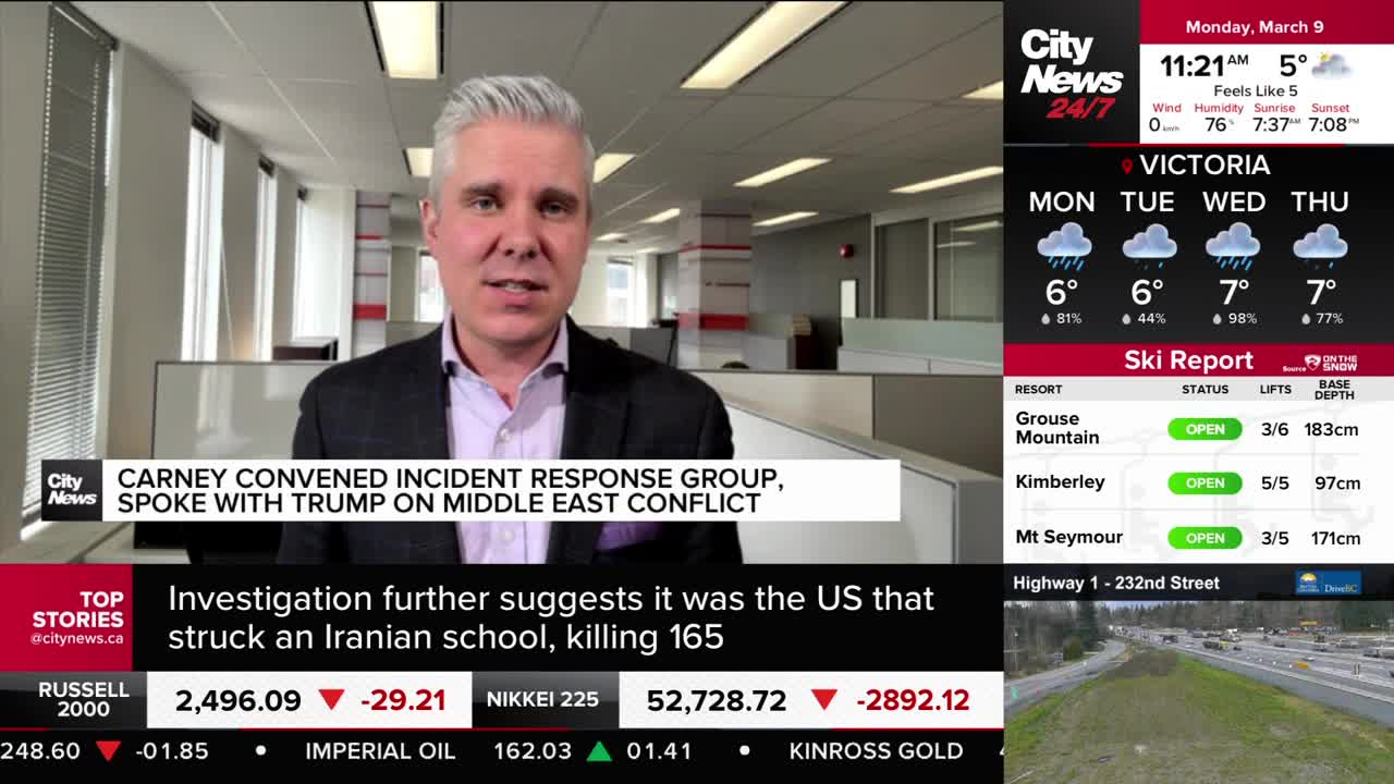 A man in a suit stands in an office, speaking to the camera. A CityNews Vancouver graphic displays a headline about Carney convening an incident response group.