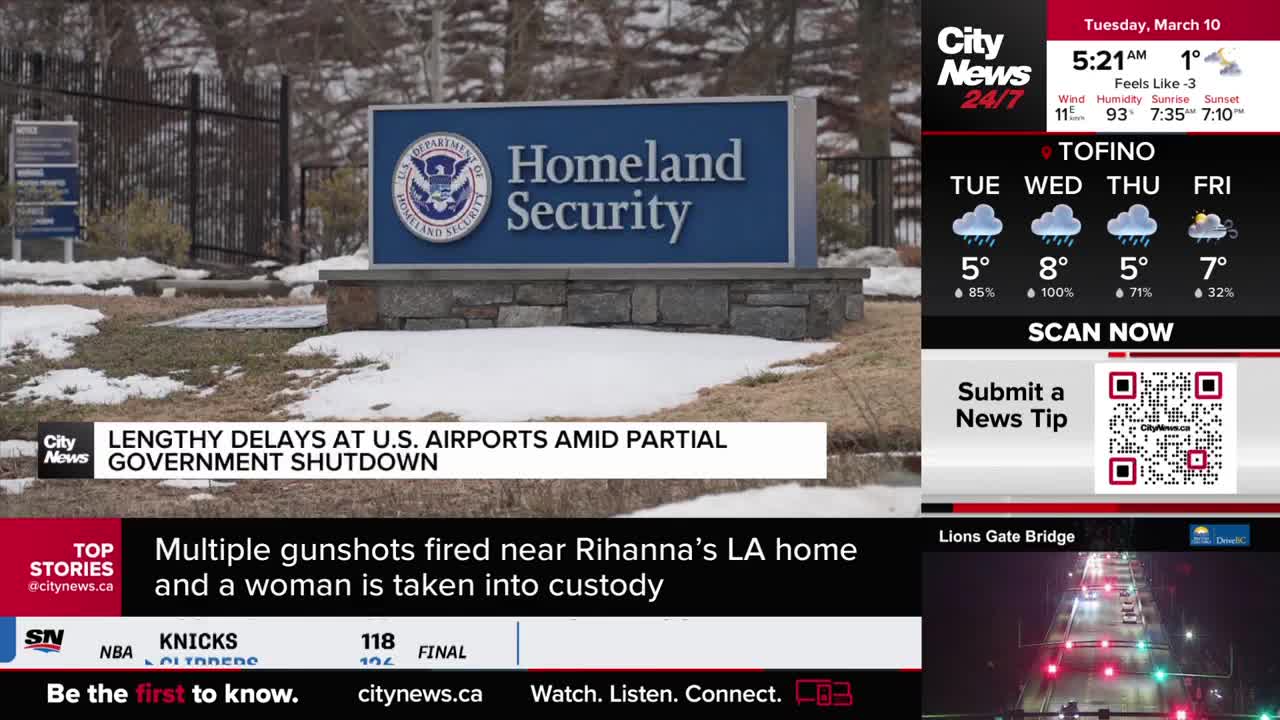 A sign for Homeland Security stands against a backdrop of snow-dusted trees and a fence. CityNews Vancouver displays a weather forecast for Tofino and a live traffic camera view of the Lions Gate Bridge.