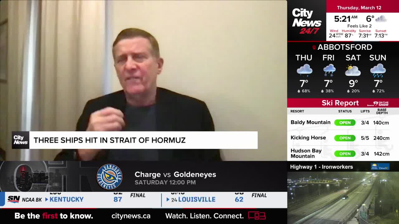 A man in a dark jacket speaks animatedly, gesturing with his hands. A news ticker below him reports "THREE SHIPS HIT IN STRAIT OF HORMUZ."