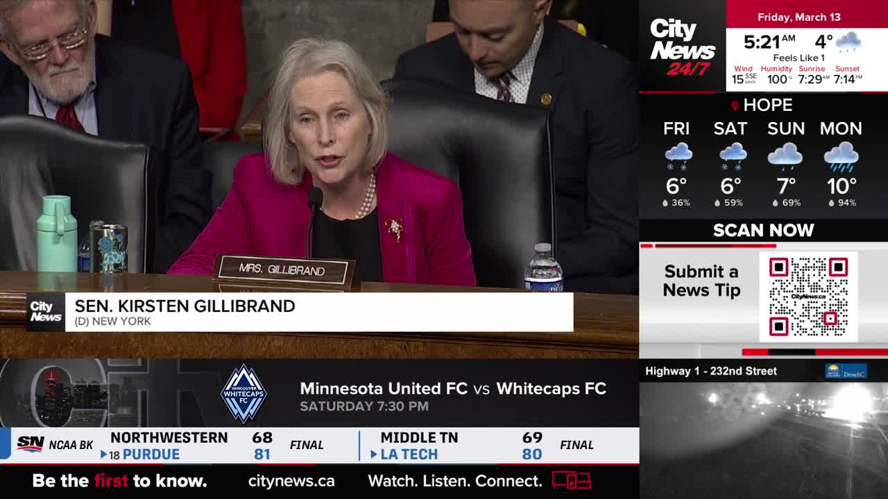 Senator Kirsten Gillibrand speaks at a hearing, her bright pink jacket a sharp contrast to the muted tones of the room. A CityNews Vancouver broadcast overlays the scene, showing weather updates and sports scores.