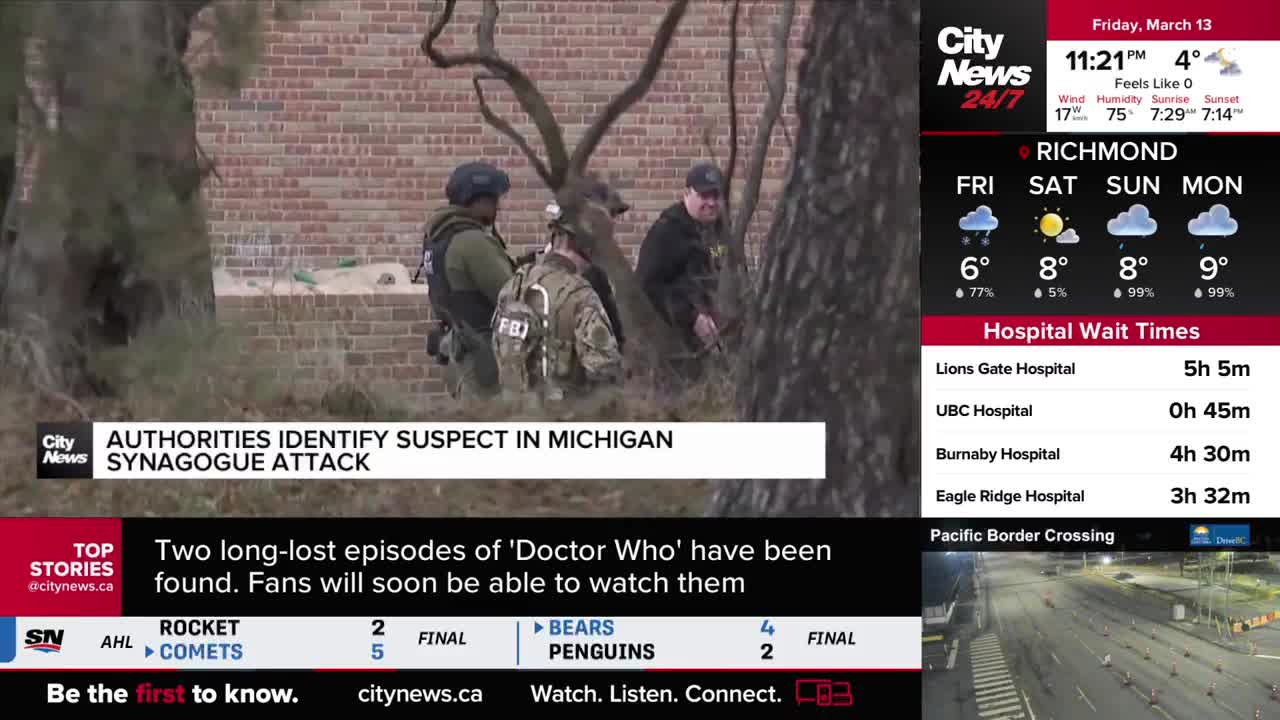 Several individuals in tactical gear stand by a brick building. One of them wears a vest with "FBI" visible on the back.