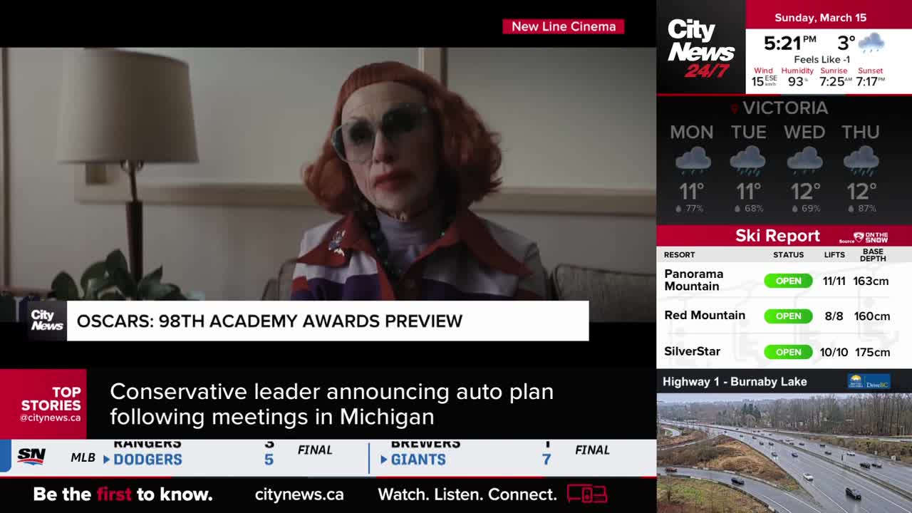 A person with red hair and heavy makeup looks directly at me, a television screen displaying "OSCARS: 98TH ACADEMY AWARDS PREVIEW" sits below. To the right, the CityNews Vancouver broadcast shows a ski report and a highway camera feed. A person with red hair and heavy makeup looks directly at me, a television screen displaying "OSCARS: 98TH ACADEMY AWARDS PREVIEW" sits below. To the right, the CityNews Vancouver broadcast shows a ski report and a highway camera feed.