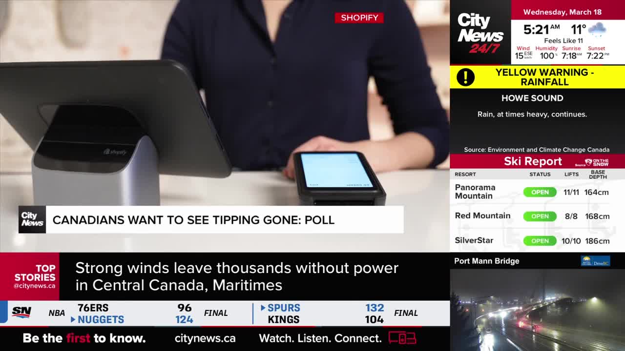 A person's hands hover over a payment terminal, ready to complete a transaction. A CityNews Vancouver broadcast displays a yellow warning for heavy rain in Howe Sound.