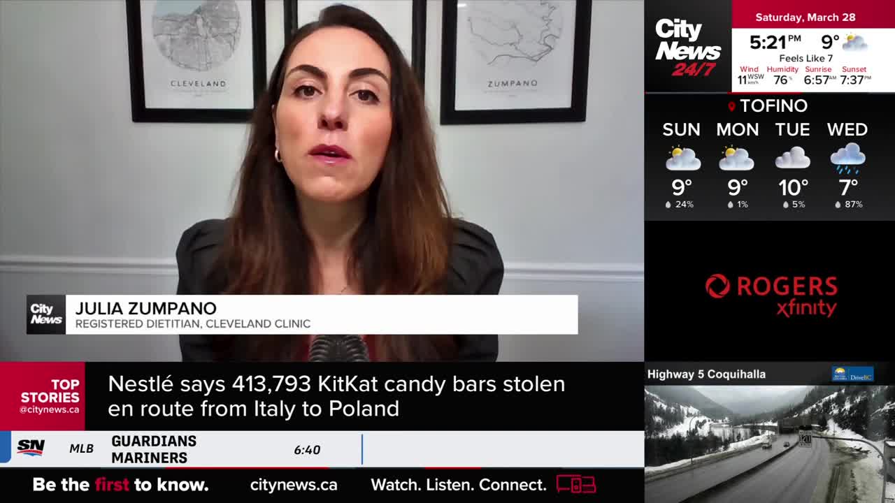 A woman speaks directly to the camera, identified as Julia Zumpano, a registered dietitian from Cleveland Clinic. Below her, a news ticker reports that Nestlé says over 400,000 KitKat bars were stolen en route from Italy to Poland.