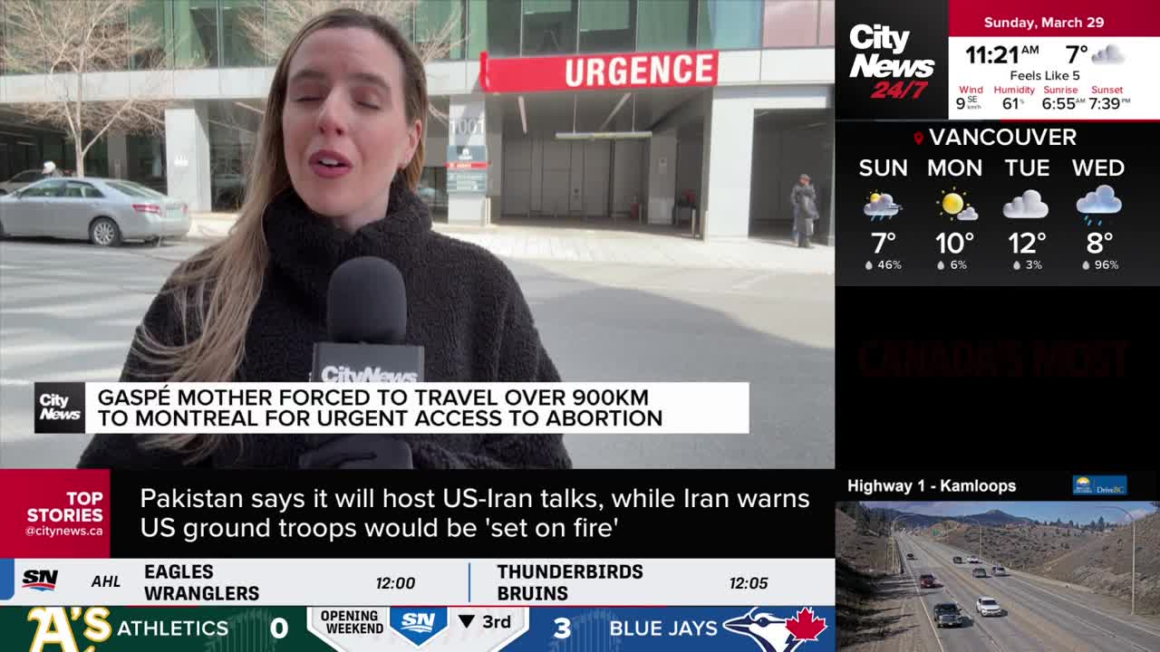 A reporter stands outside a building marked "URGENCE," holding a microphone. A silver car drives past behind her.