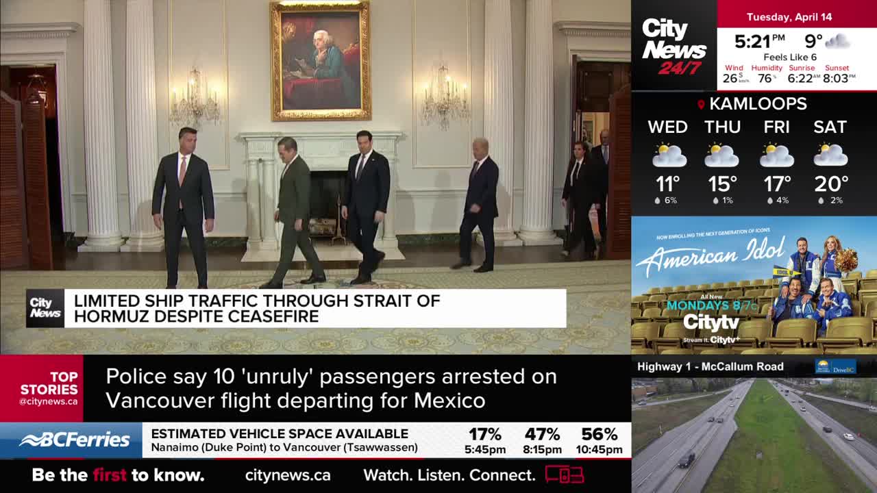 A group of men in suits walks across a polished floor in a grand room. A news ticker below reports on limited ship traffic and arrests at Vancouver airport.