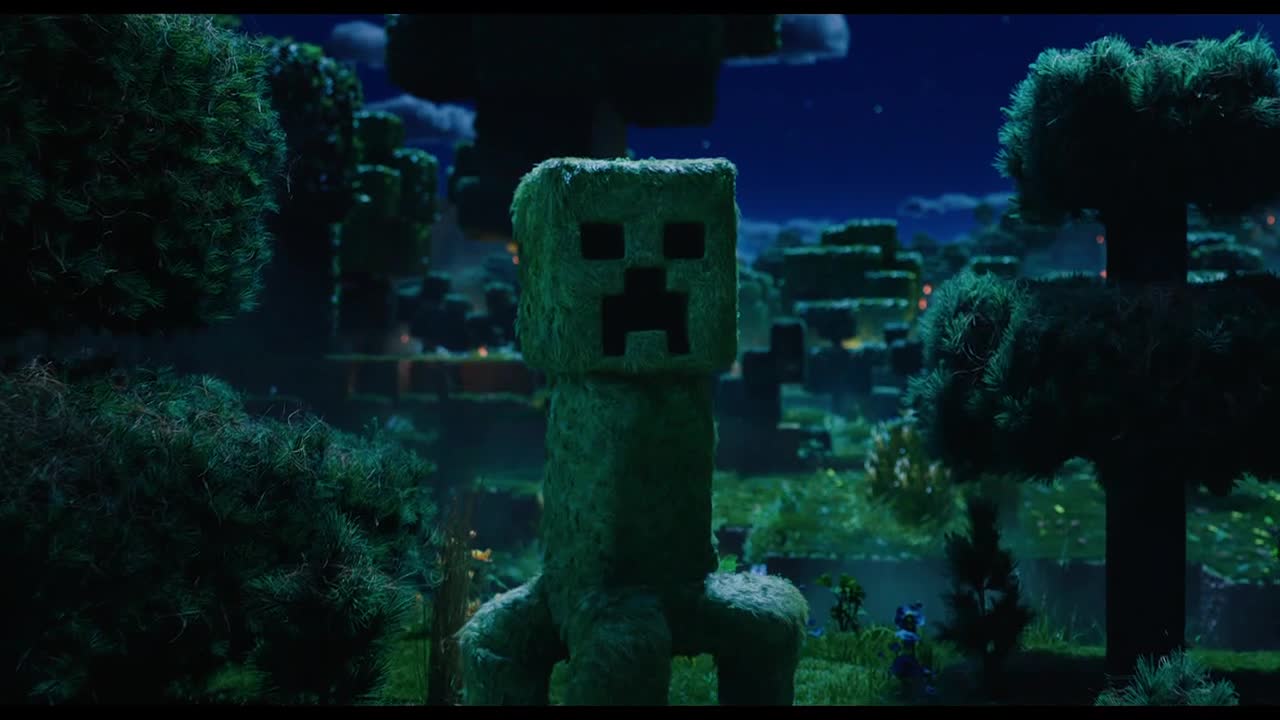 A large Creeper, made of green, textured material, stands in a Minecraft-like forest. The night sky glows behind the blocky trees and distant structures.
