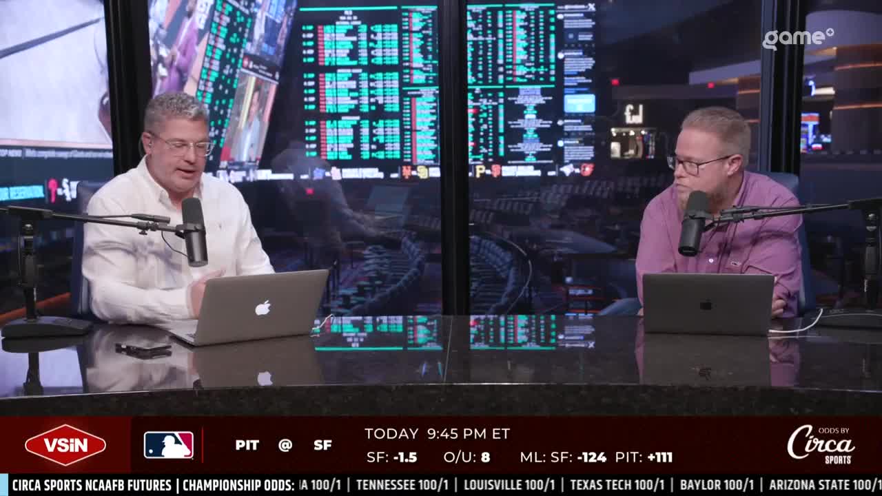 Two men sit at a desk, each with a laptop and microphone, in front of a wall of data screens. The broadcast is from Game+, with odds from Circa Sports displayed on the bottom of the screen.
