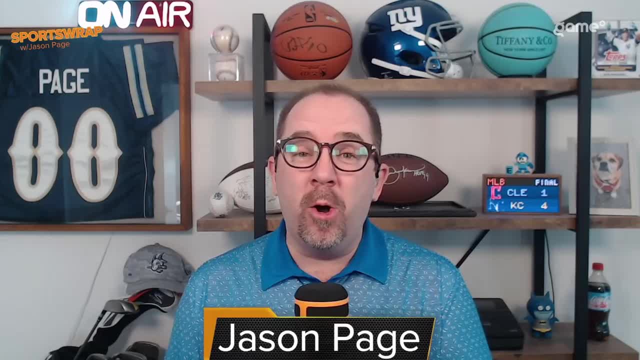 Jason Page, framed by a sports-themed backdrop, is speaking directly to the camera. The "ON AIR" sign glows above him, and a Game+ logo is visible on a shelf behind him.

