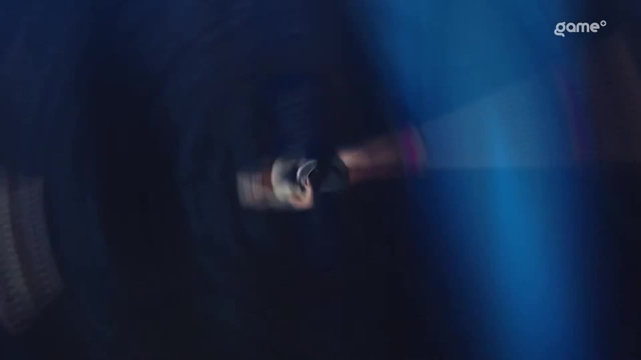 A figure is holding something, moving quickly. The background is a deep blue, with the Game+ logo in the corner.
