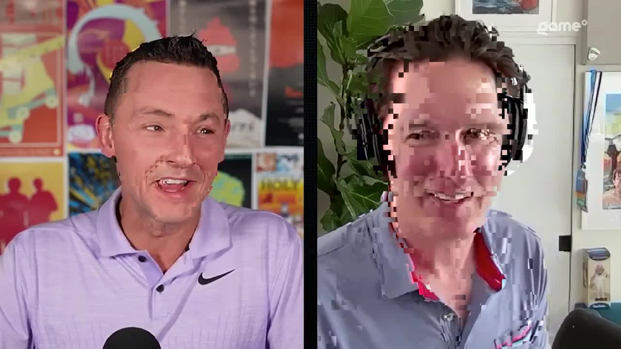 On the left, a man in a lavender polo shirt is speaking, his face animated. Across the screen, another man with pixelated features smiles, wearing headphones.
