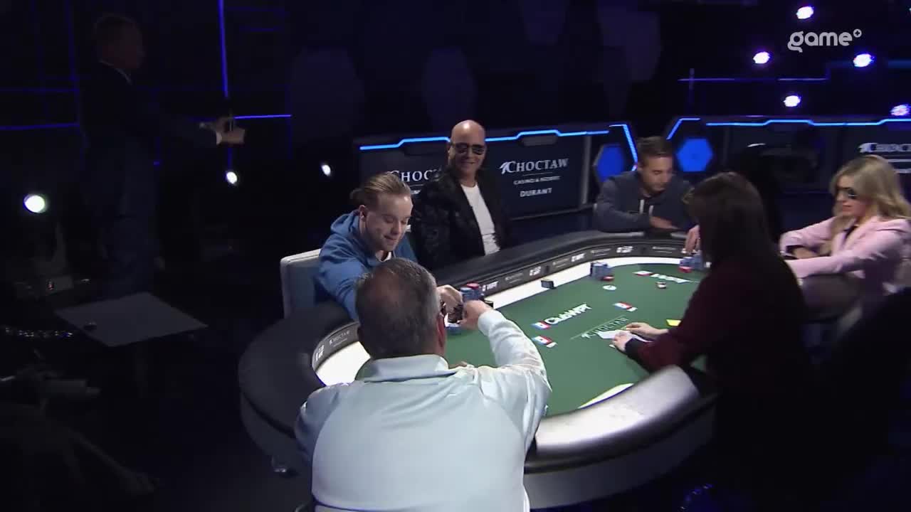 A man in a light blue hoodie leans forward, smiling as he looks at his cards. Across the felt, a player in a white polo shirt is about to place his chips down. The Game+ broadcast is underway from Choctaw Casino & Resort in Durant. A man in a light blue hoodie leans forward, smiling as he looks at his cards. Across the felt, a player in a white polo shirt is about to place his chips down. The Game+ broadcast is underway from Choctaw Casino & Resort in Durant.