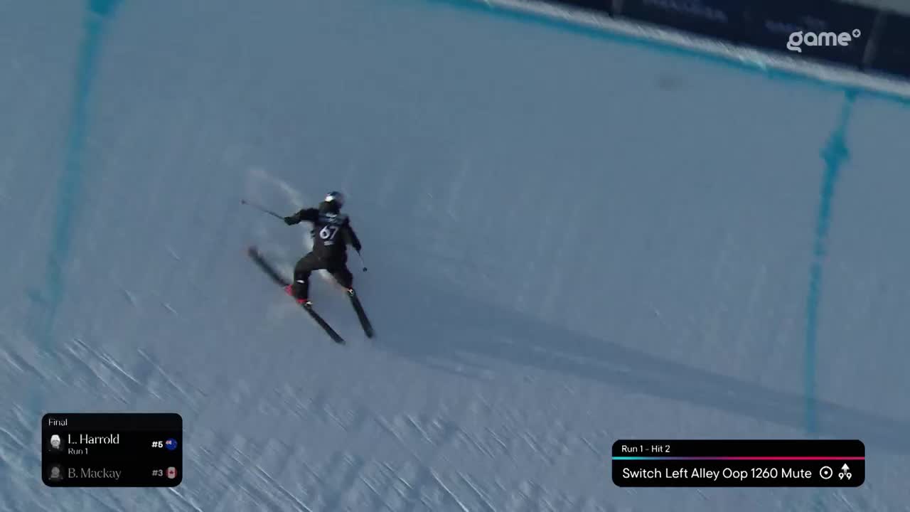 A skier in black with the number 67 on their back carves down the icy slope. The Game+ broadcast displays details of the run, including "Switch Left Alley Oop 1260 Mute."