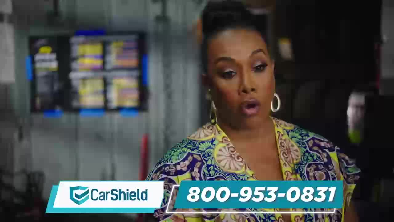 A woman with a colorful patterned shirt speaks directly to the camera. A phone number and the CarShield logo appear on screen.