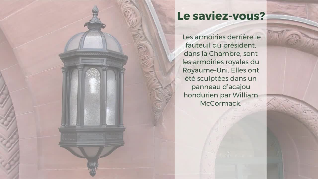 A decorative, ornate lantern hangs on a pinkish-red stone wall. The text to the right highlights architectural details found inside the Legislative Assembly of Ontario.

